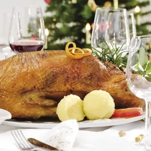 Roast goose, red cabbage, dumplings on a festively decorated table