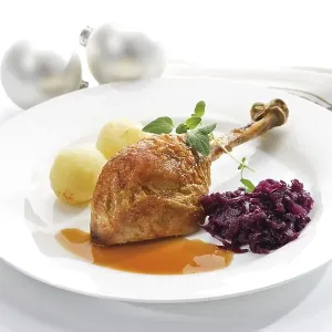 Roast turkey drumstick served on a white plate with red cabbage