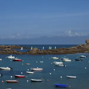 Rock formation Le De, cube, boats in the port of Tregastel