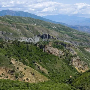 Rocks and green hills stretch under a blue sky Rocks and green hills stretch under a blue sky