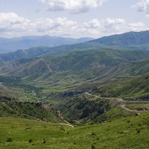 Rolling hills and mountains around a wide valley with green vegetation Rolling hills and mountains around a wide valley with green vegetation