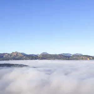 Ronda, malaga, spain, Mountain range and distant hills emerge from a thick blanket of fog or clouds