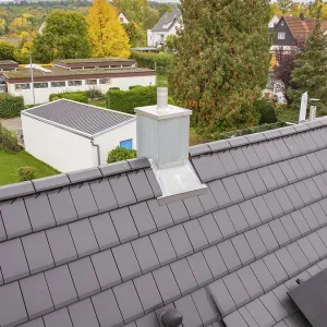 Roof with anthracite-colored tiles and modern chimney
