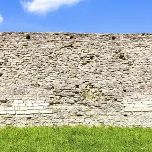 Rough stone wall of the ancient medieval fortress Izborsk in summer Rough stone wall of the ancient medieval fortress Izborsk in summer