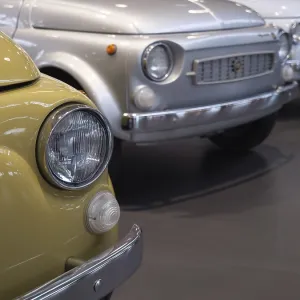 Row of classic cars with yellow and silver vehicle in the foreground