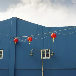 Scenic Chinatown architecture with bright blue building wall and red lanterns line from Singapore