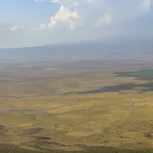 Scenic panoramic view of a valley with distant mountains and clouds