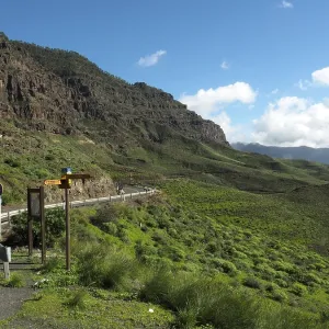 Scenic road through green mountains with clear skies Scenic road through green mountains with clear skies