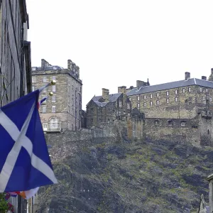 Scottish castle on a hill surrounded by buildings and a Scottish flag Scottish castle on a hill surrounded by buildings and a Scottish flag
