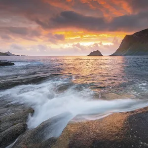 Sea surf in warm evening light with coastal landscape on Lofoten