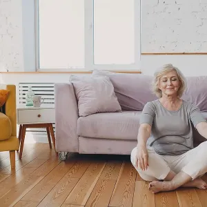 Senior adult smiling old granny practicing yoga at home living room