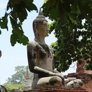Serene buddha statue sits in peaceful meditation amidst crumbling temple ruins Serene buddha statue sits in peaceful meditation amidst crumbling temple ruins