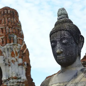 Serene buddha statue stands tall amidst ancient temple ruins Serene buddha statue stands tall amidst ancient temple ruins