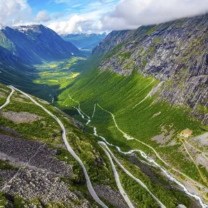 The serpentine road meanders on the green slopes of the canyon