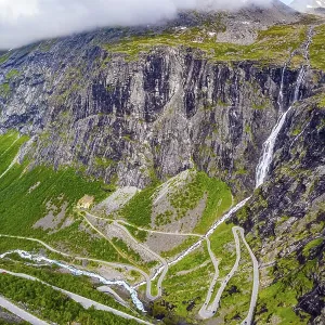 The serpentine road meanders on the green slopes of the canyon