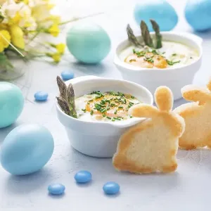 Shirred eggs (Oeuf cocotte) or baked eggs with green asparagus with Easter toast bunny and eggs