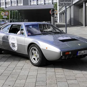 Silver Ferrari classic car with number 106 on cobblestones Silver Ferrari classic car with number 106 on cobblestones