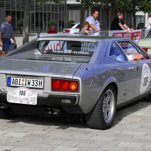 Silver Ferrari classic car with number 106 in an urban environment Silver Ferrari classic car with number 106 in an urban environment
