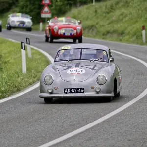 Silver-grey classic car with race number on a winding road Silver-grey classic car with race number on a winding road