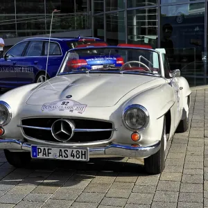 Silver Mercedes-Benz vintage convertible in sunlight on cobblestones Silver Mercedes-Benz vintage convertible in sunlight on cobblestones