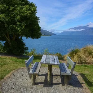 Single picnic table overlooking lake and mountains in scenic setting