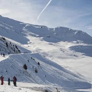 Skiers stand at edge of ski slopes