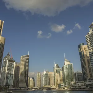 Skyscrapers of a modern city rise into the blue sky with few clouds