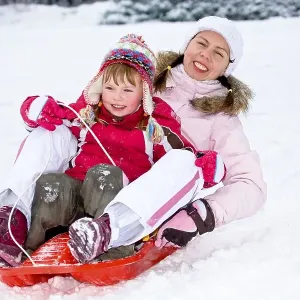 Sledding mother and daughter