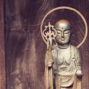 Small Buddha statue near wooden temple wall in Japan Small Buddha statue near wooden temple wall in Japan