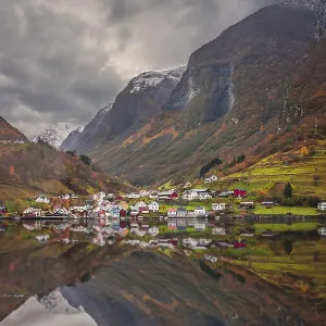 Small homes on the shore of a fjord photographed from a Fjords sightseeing cruise boat leaving Flam in autumn Small homes on the shore of a fjord photographed from a Fjords sightseeing cruise boat leaving Flam in autumn