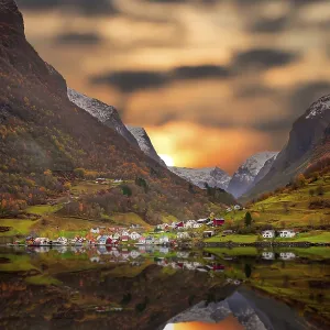 Small homes on the shore of a fjord photographed from a Fjords sightseeing cruise boat leaving Flam in autumn Small homes on the shore of a fjord photographed from a Fjords sightseeing cruise boat leaving Flam in autumn