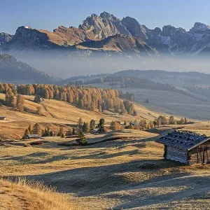 Small hut on alp in front of mountains in the morning light