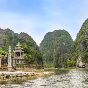 Small temple with forested limestone rocks Small temple with forested limestone rocks