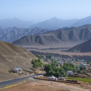 Small village Toktogul between dry mountain landscape
