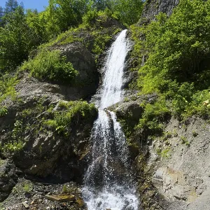 Small waterfall falling over green rocks