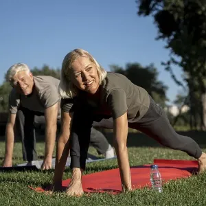 Smiley elder couple practicing yoga outdoors Smiley elder couple practicing yoga outdoors