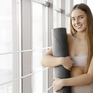 Smiley woman holding yoga mat Smiley woman holding yoga mat