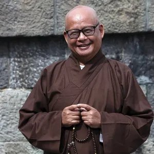 Smiling monk wearing traditional robe at Kotokuin Temple in Kamakura Smiling monk wearing traditional robe at Kotokuin Temple in Kamakura