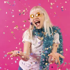 Smiling at a party throwing confetti in sunglasses