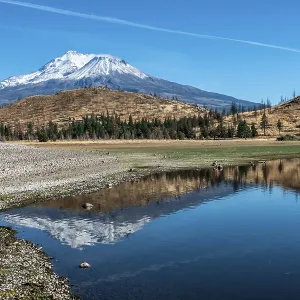 Snow capped mount shasta with a blue sky and reflection in lake Snow capped mount shasta with a blue sky and reflection in lake