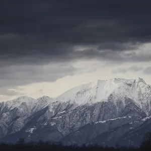 Snow-capped mountain with dark clouds Snow-capped mountain with dark clouds