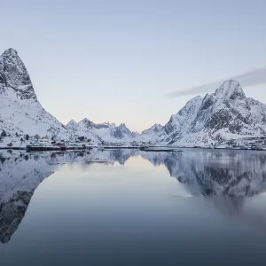 Snow-covered mountains reflected in fjord Snow-covered mountains reflected in fjord