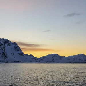 Snowy coastal landscape at sunset