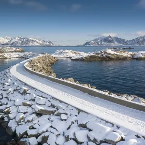 Snowy jetty in the sea, mountains in the back