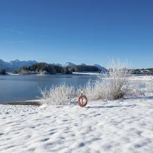 Snowy lake with a clear view of distant mountains