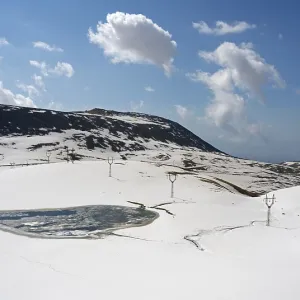 Snowy mountain landscape with calm sky and distant clouds