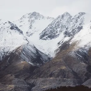 Snowy mountain landscape with clearly visible peaks under a cloudy sky Snowy mountain landscape with clearly visible peaks under a cloudy sky