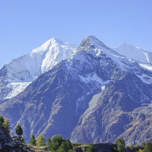 Snowy mountain peaks with rocks and clear sky
