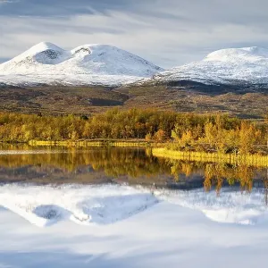 Snowy mountains in Abisko National Park reflected in lake Vuolio Njahkajavri Snowy mountains in Abisko National Park reflected in lake Vuolio Njahkajavri