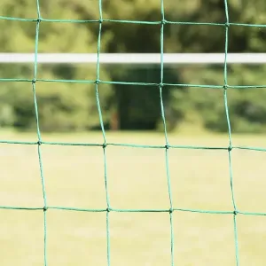Empty soccer field seen through the net of the goal Empty soccer field seen through the net of the goal